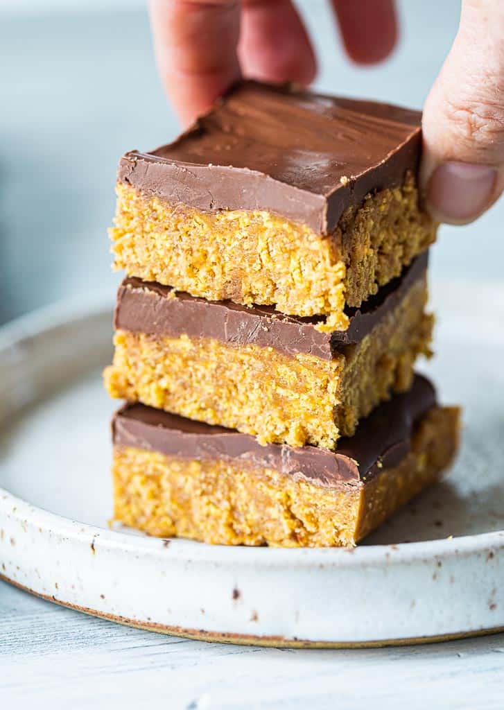 A hand stacking peanut butter bars three high.
