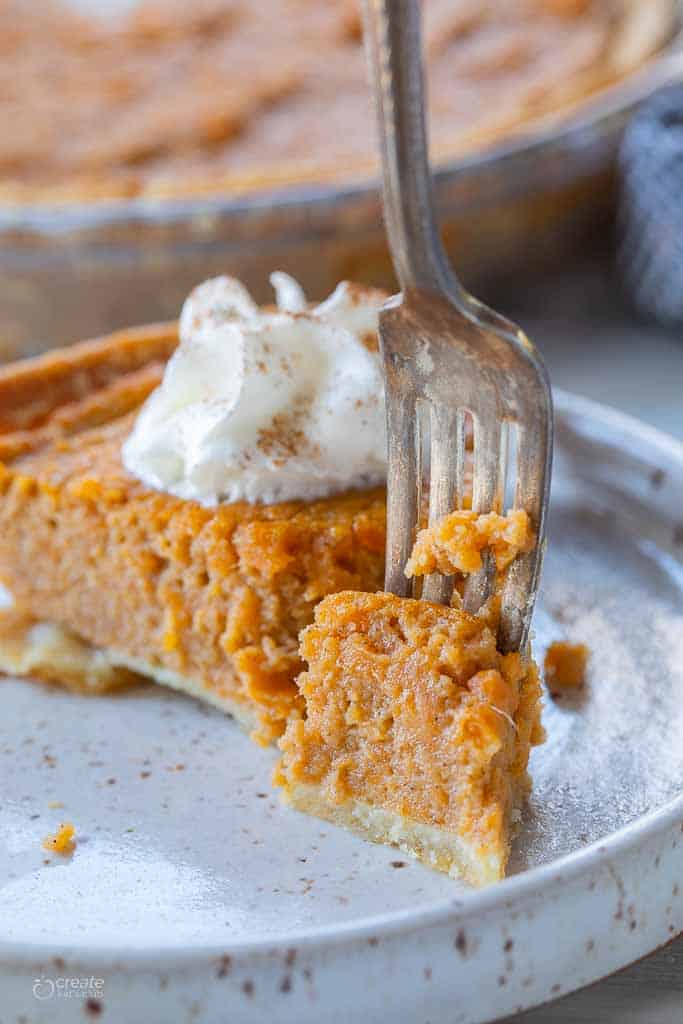 fork scooping into slice of sweet potato pie