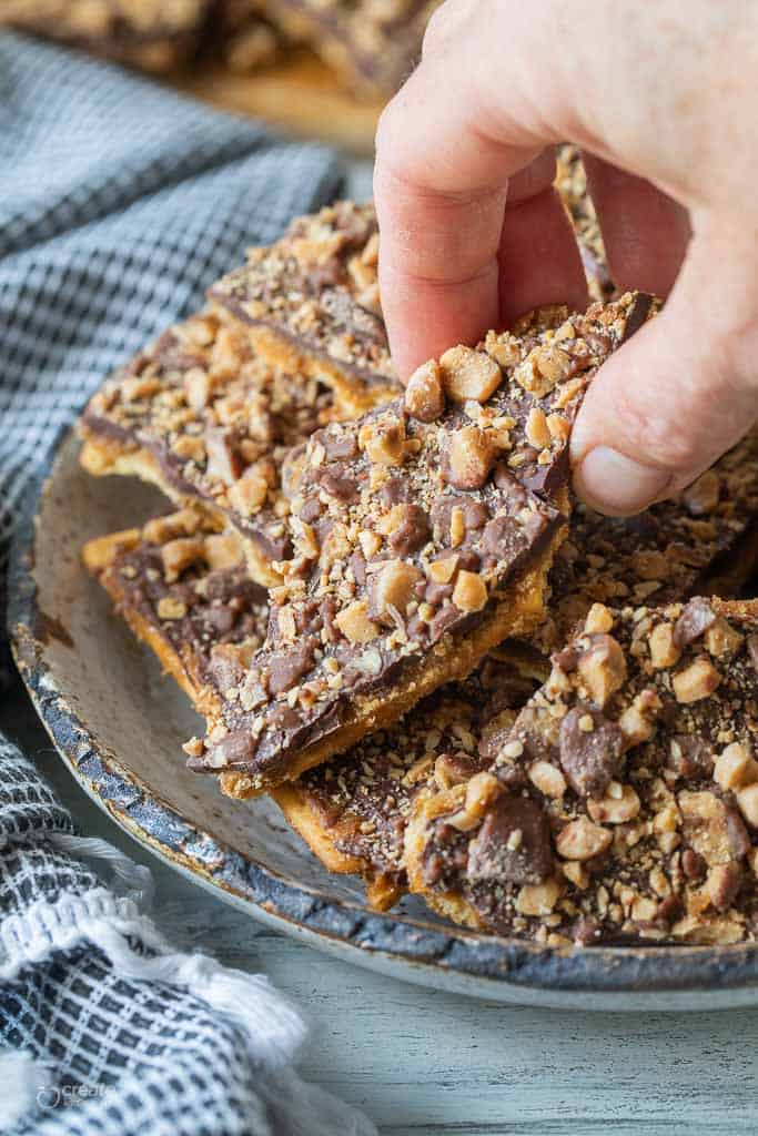 hand picking up a piece of saltine toffee