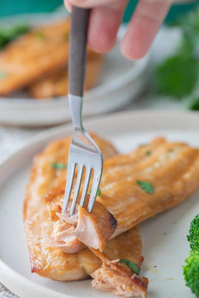 fork scooping into salmon filet