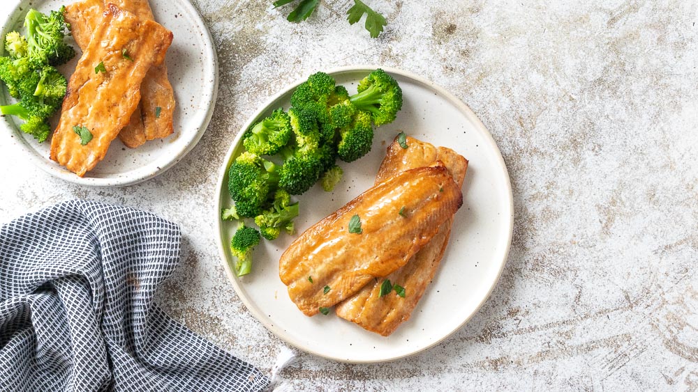 top down view of broiled salmon with steamed broccoli on plate