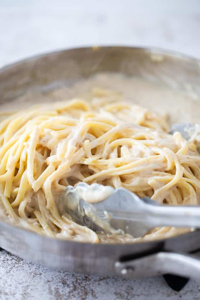 tongs mixing gluten free chicken fettuccini alfredo