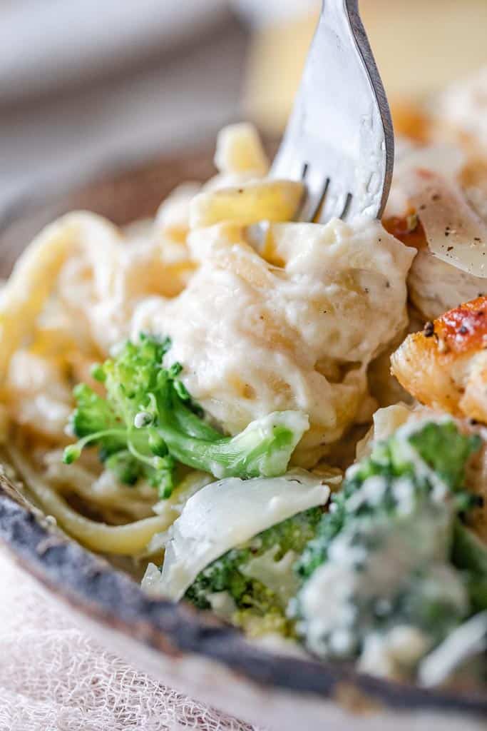 healthy chicken fettuccini alfredo in a bowl with fork