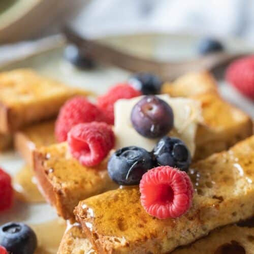 French toast sticks topped with syrup, butter and fruit
