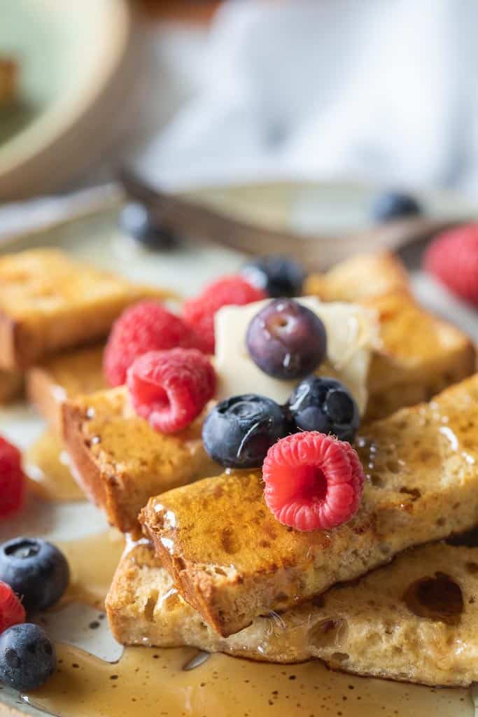 French toast sticks topped with syrup, butter and fruit