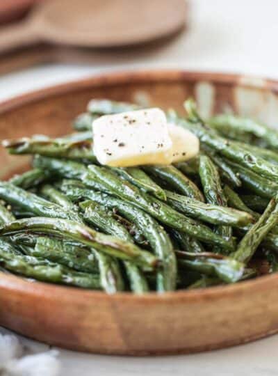 crispy green beans topped with butter in a bowl