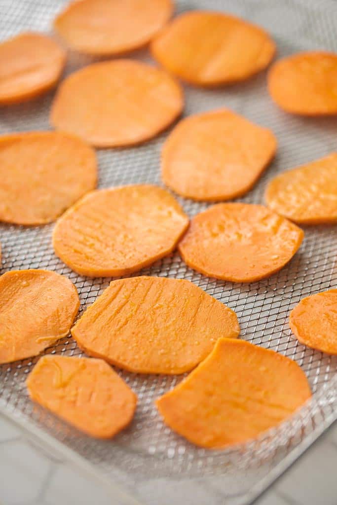 sliced sweet potatoes on an air fryer tray