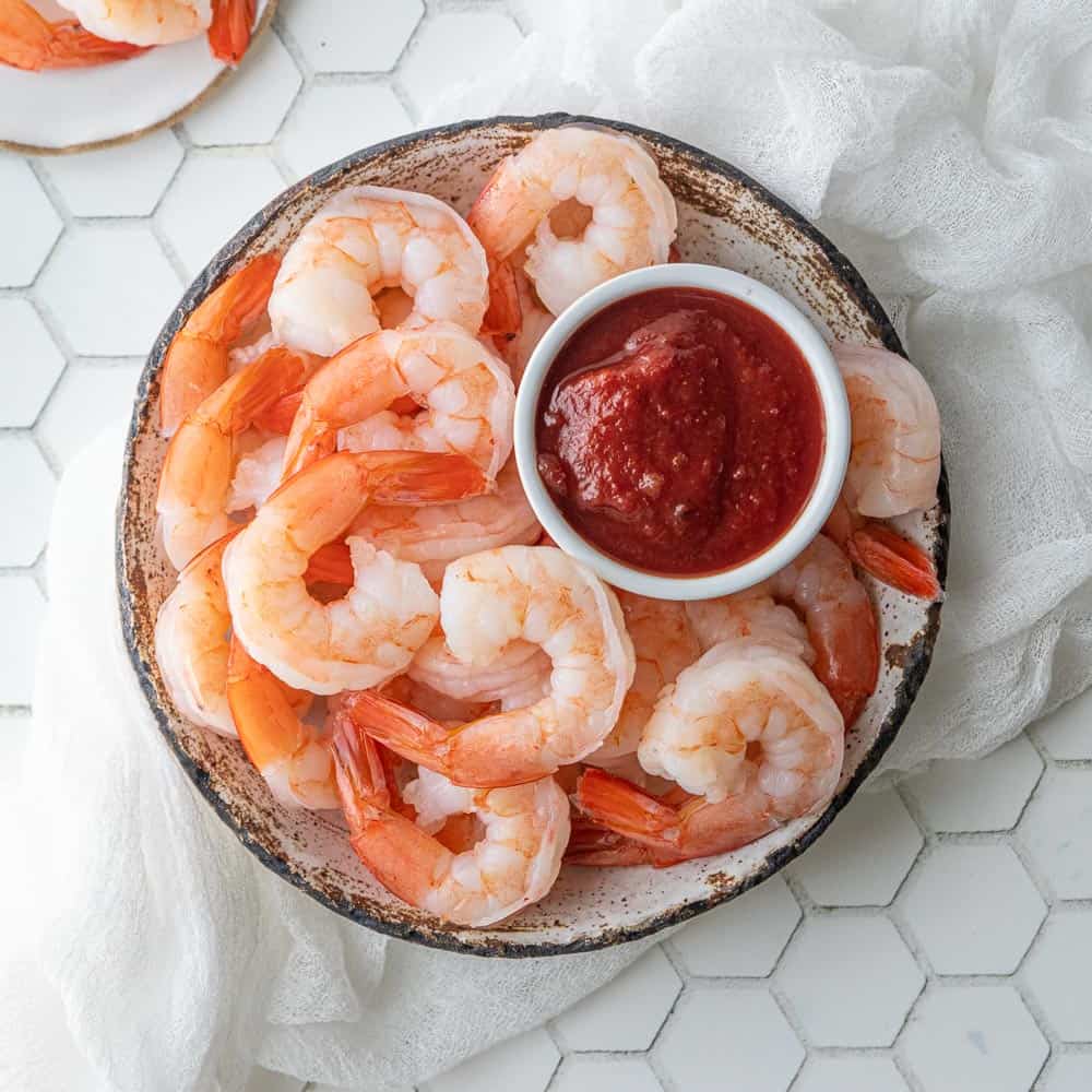 boiled shrimp in a bowl with cocktail sauce
