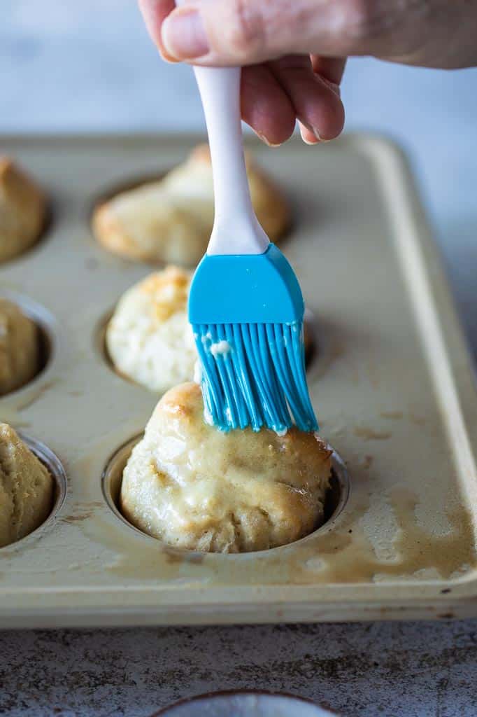 gluten free roll brushed with butter in muffin tin