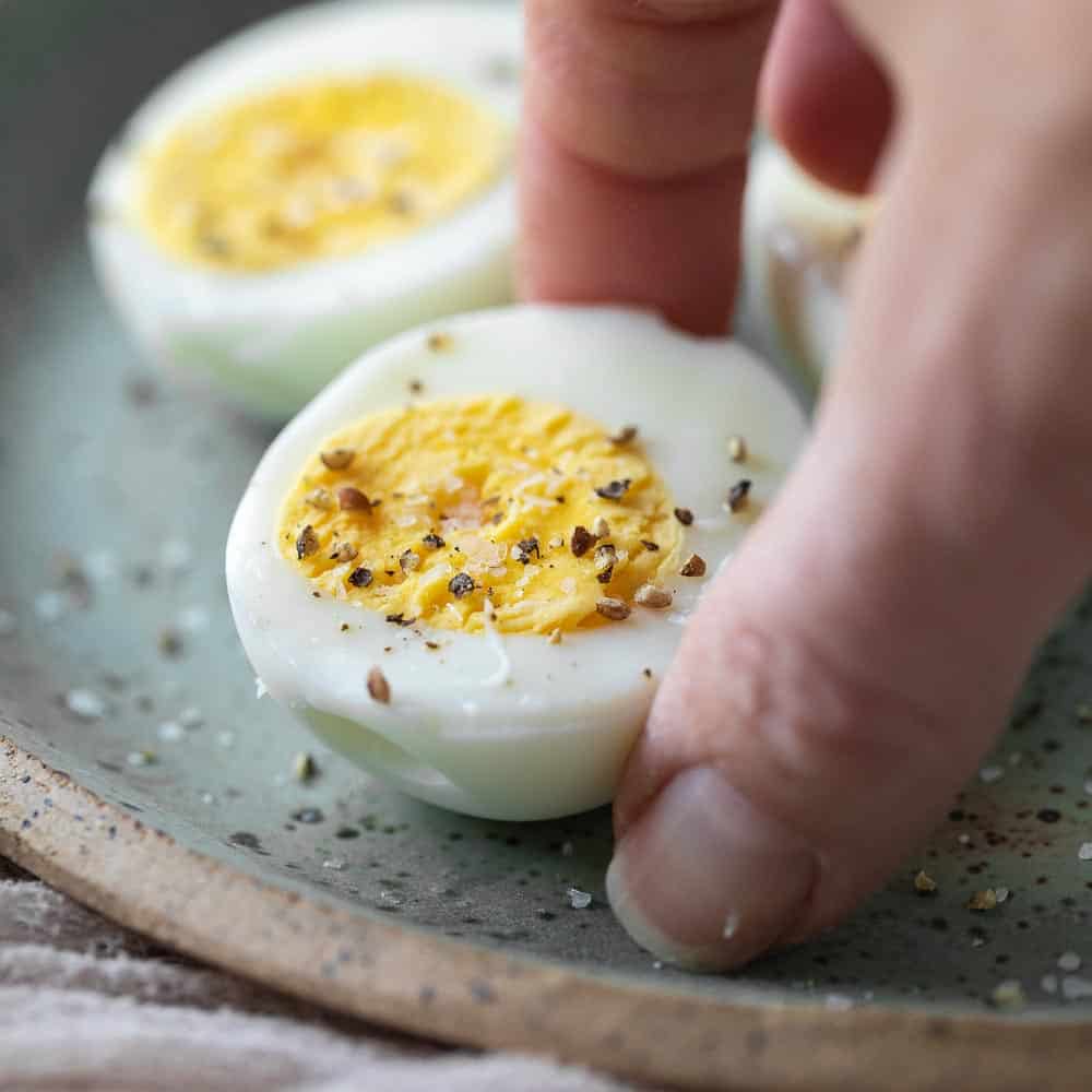 hand picking up seasoned hard boiled egg