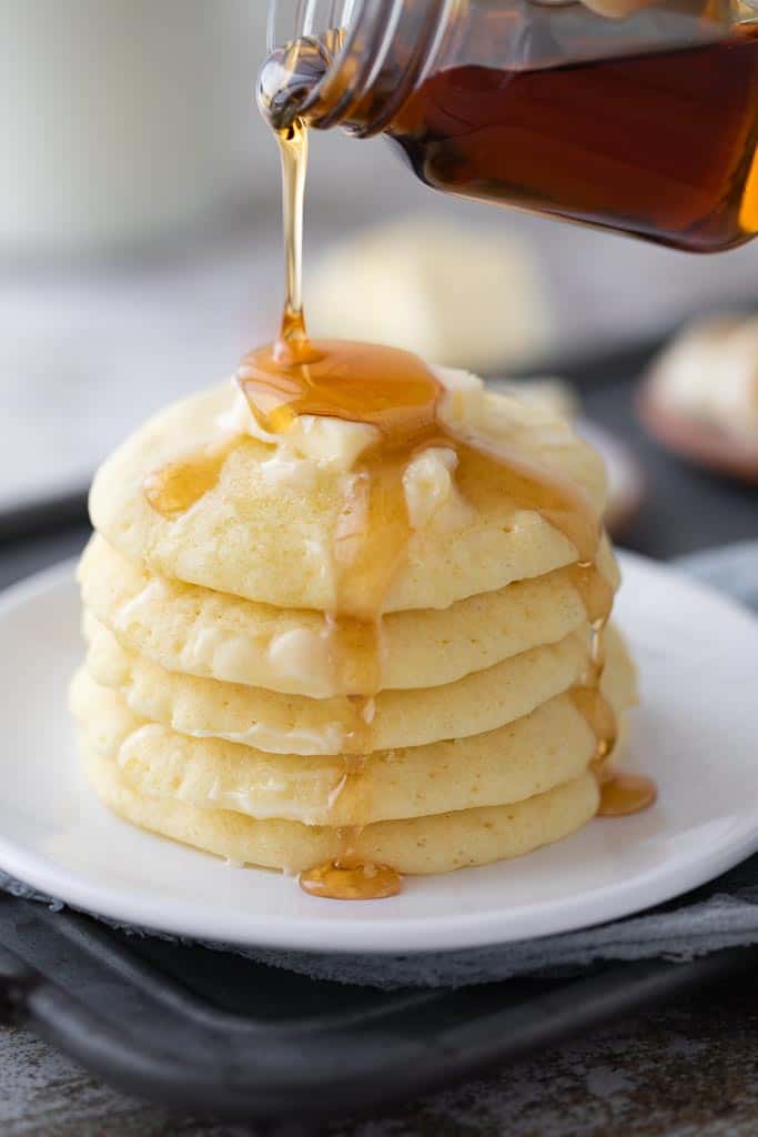 maple syrup drizzled on top of pancake stack