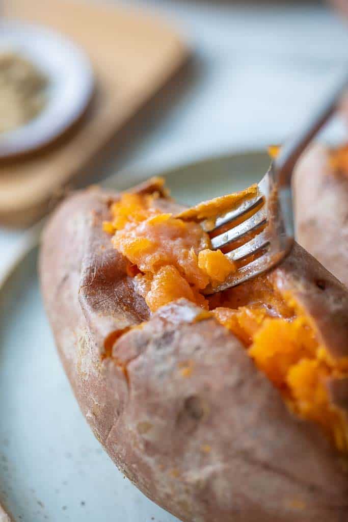 fork scooping into cooked sweet potato