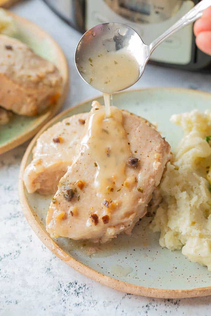 gravy ladled over pork chops on plate