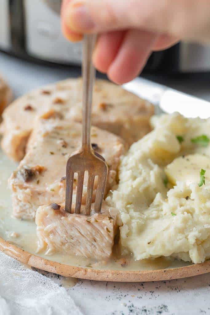 fork scooping into a piece of pork chop