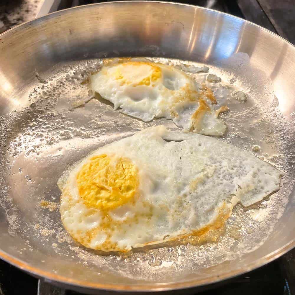 two eggs cooking in sauté pan