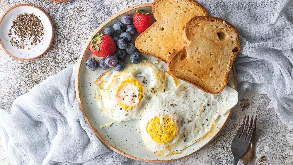 top down view of plate with eggs, toast and berries