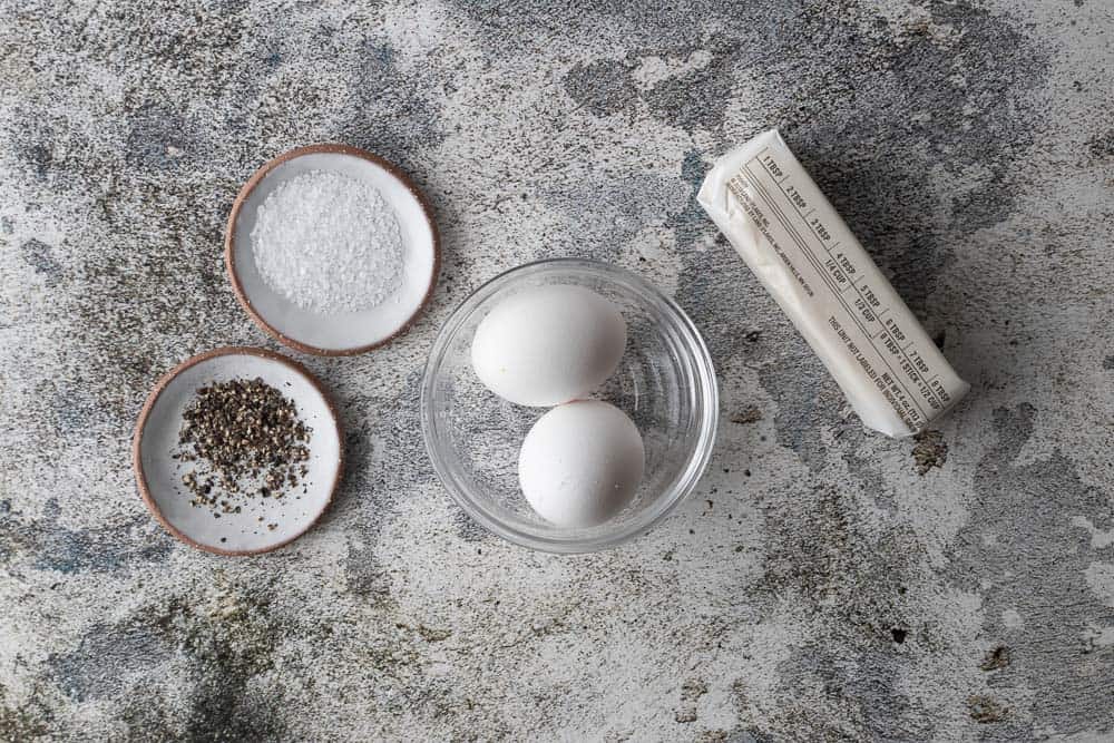 salt, pepper, eggs and butter on counter