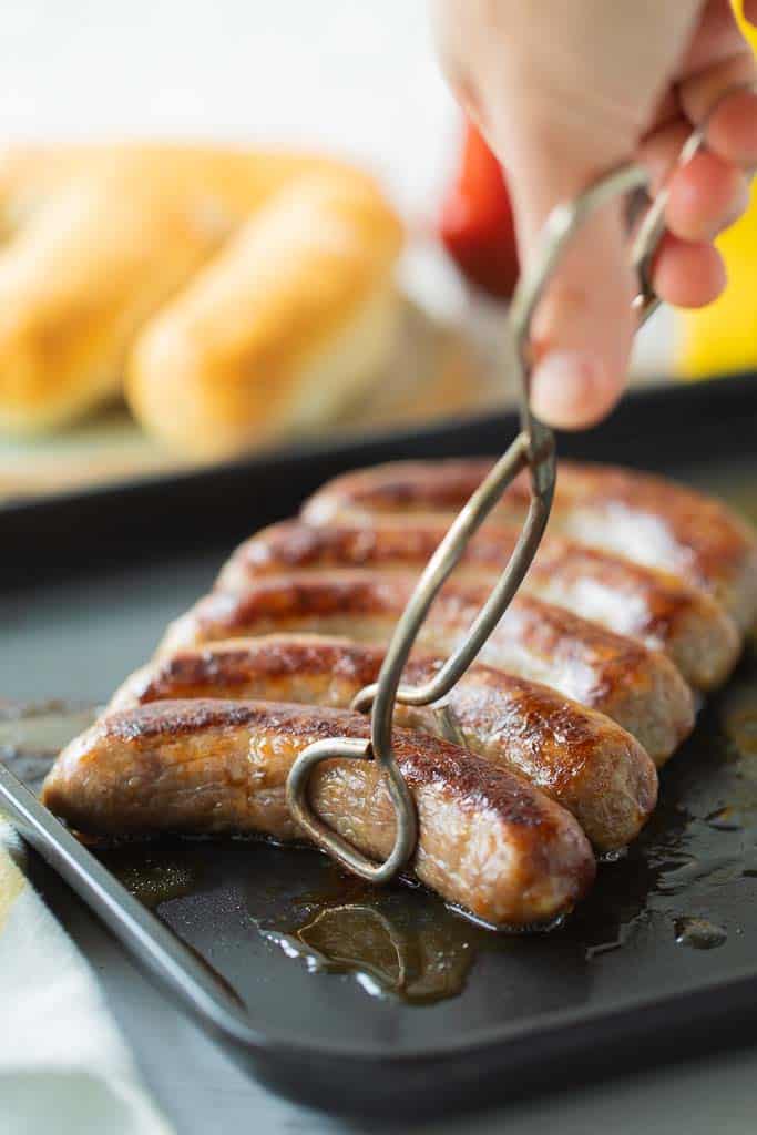 tongs picking up an air fryer brat