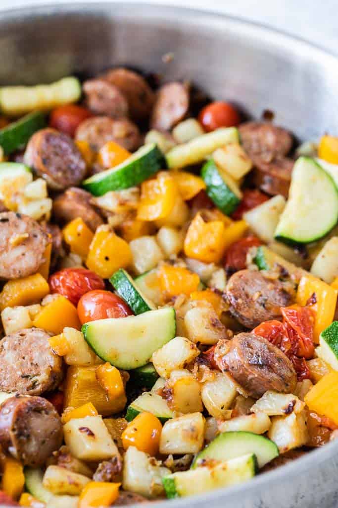 cooked vegetables and sliced sausage in skillet