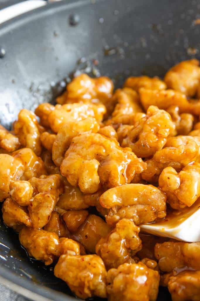 Gluten-free orange chicken in a wok.