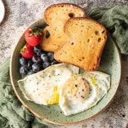 over easy eggs on plate with toast and berries