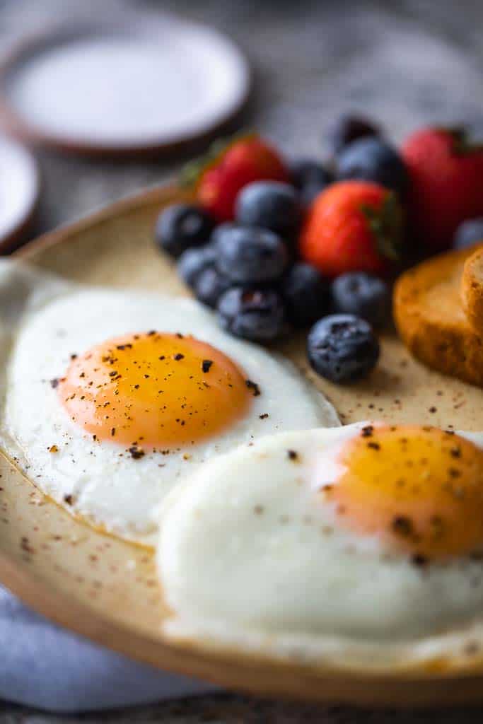 sunny side up eggs on plate with berries