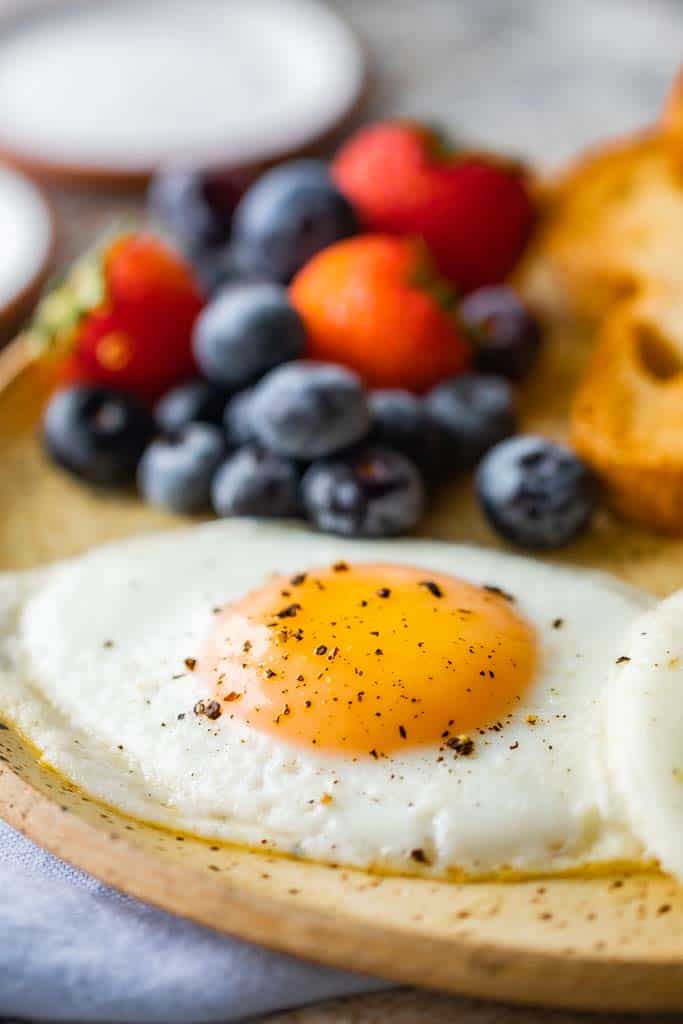 sunny side up egg on plate with fruit.