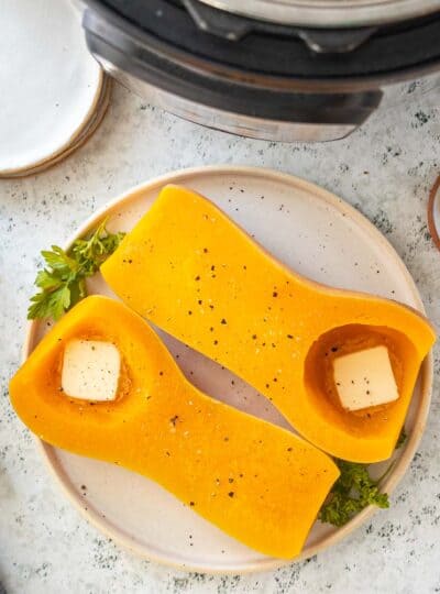 top down view of two butternut squash halves with butter