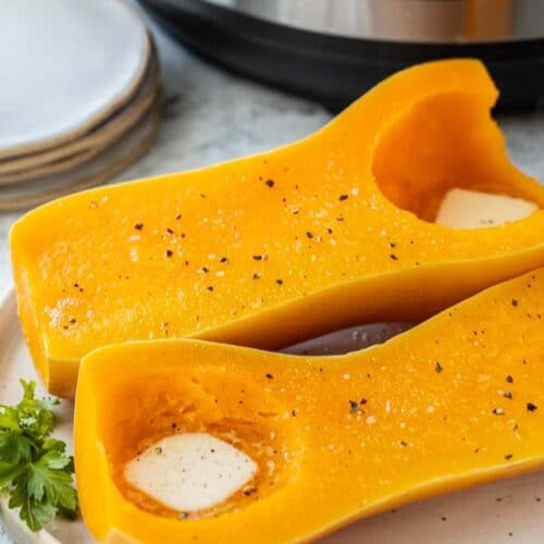 two butternut squash halves spread with butter