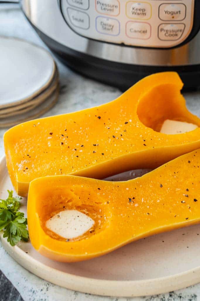 two butternut squash halves spread with butter