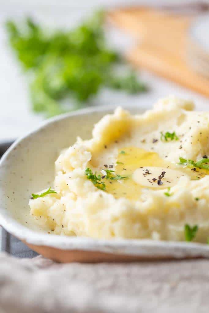 close up view of mashed potatoes topped with butter