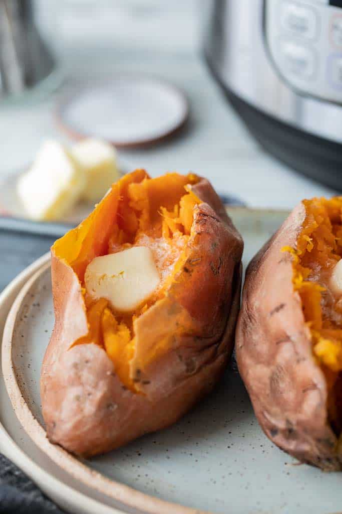 two sliced sweet potatoes topped with butter