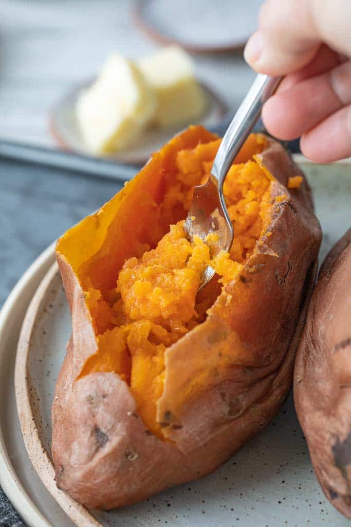 fork scooping into cooked sweet potato
