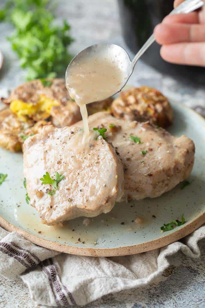 gravy ladled over pork chops