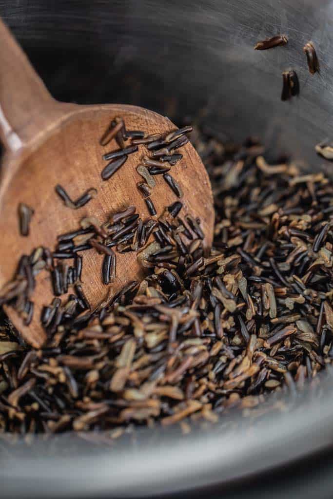 wooden spoon stirring wild rice