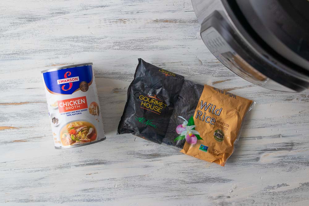can chicken broth and bag of wild rice on countertop