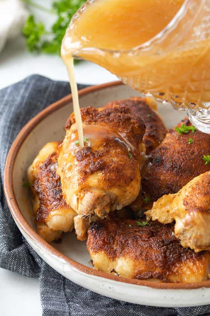 broth drizzled over the top of crispy chicken thighs