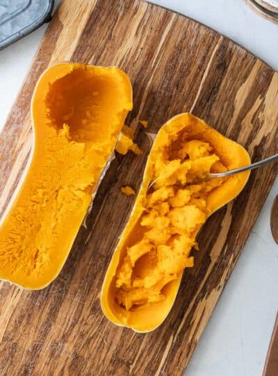 spoon scooping butternut squash from the skin