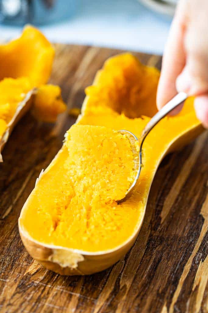 close up view of spoon scooping butternut squash from skin