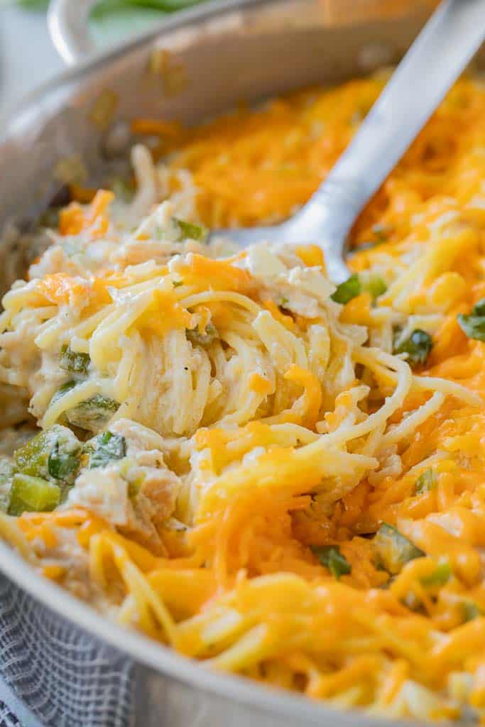 spoon scooping into dish of cheesy pasta