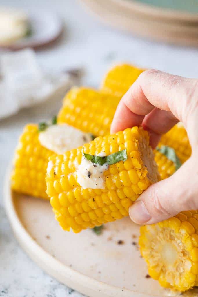 hand holding buttery corn cob