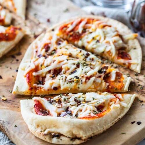 a sliced cheese naan pizza on a pizza board