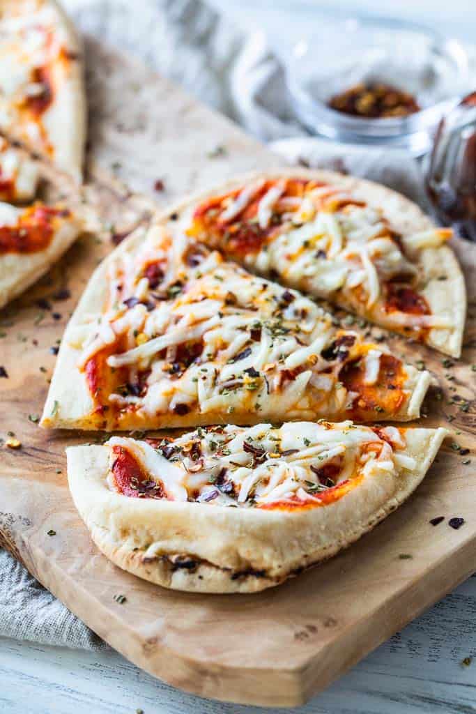 a sliced cheese naan pizza on a pizza board