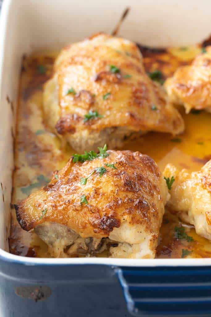 close up of baked chicken thighs in a baking dish