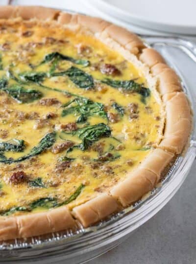 close up of baked sausage and spinach quiche