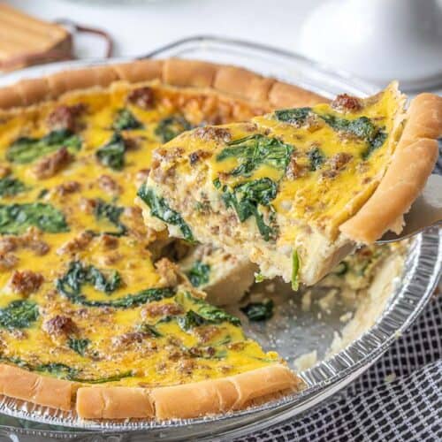 slice being removed from a baked dairy free quiche