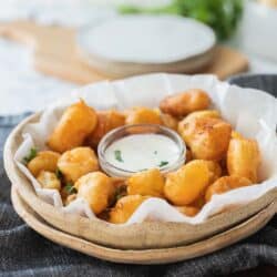 close up of fried cheese curds with dipping sauce.