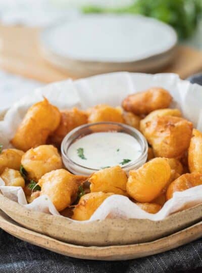 close up of fried cheese curds with dipping sauce.