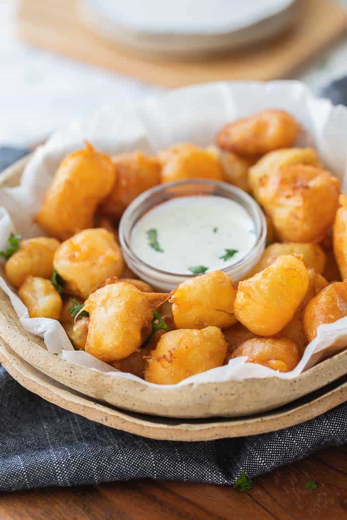cheese curds in serving dish with dipping sauce.