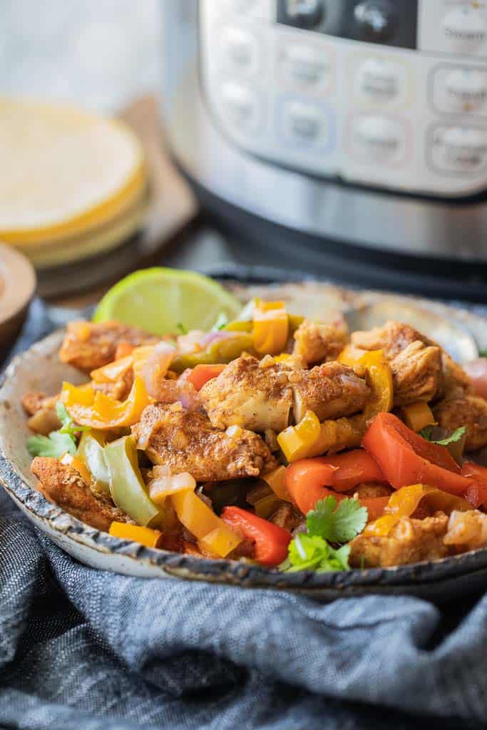 bowl with shredded chicken and sautéed pepper slices